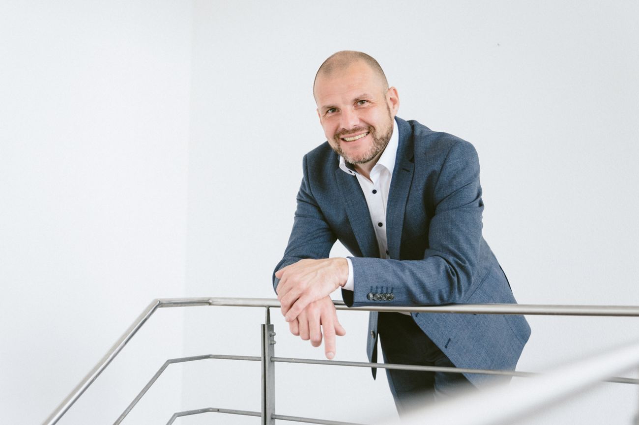 Businessportrait im Studio, Mann lehnt an geländer