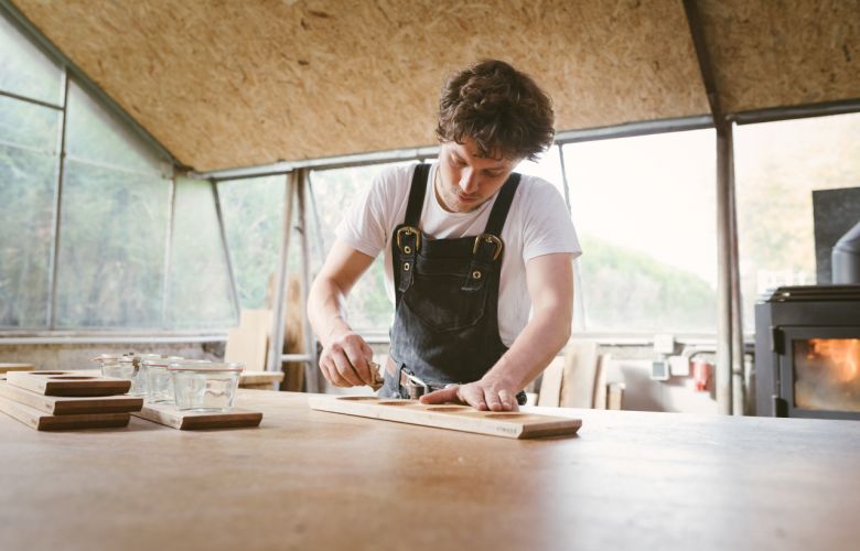 Schreiner beim ölen eines Brettes